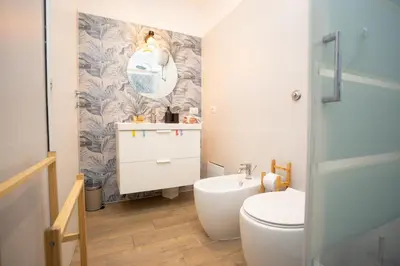 a bathroom with a toilet and a sink and a mirror at Da Cesare e Chloe al Colosseo in Rome