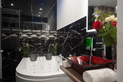 a bathroom with a white tub and a red sink at farnese jacuzzi apartment in Rome