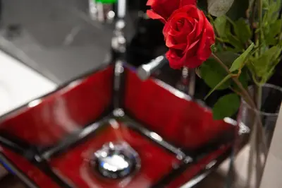 a red vase with a red rose in it at farnese jacuzzi apartment in Rome
