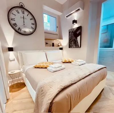 a bedroom with a large bed with a clock on the wall at THE BREAK - Campo Marzio Studio in Rome