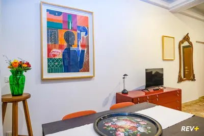 a dining room with a table and a painting on the wall at Art Apartment Rome City Center in Rome