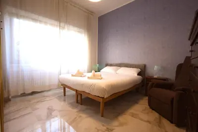 a bedroom with a bed and a couch and a window at Graziano Holiday House in Rome