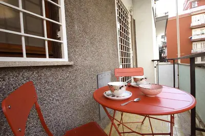 a red table with two cups on it on a balcony at Graziano Holiday House in Rome
