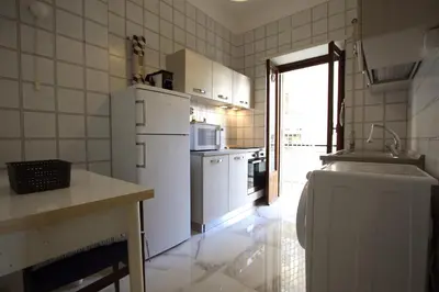 a kitchen with white appliances and a refrigerator at Graziano Holiday House in Rome