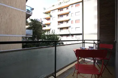 a balcony with a table and chairs and a building at Graziano Holiday House in Rome