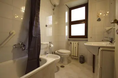 a bathroom with a toilet and a sink and a tub at Graziano Holiday House in Rome