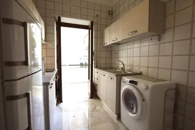 a kitchen with a washing machine and a sink at Graziano Holiday House in Rome