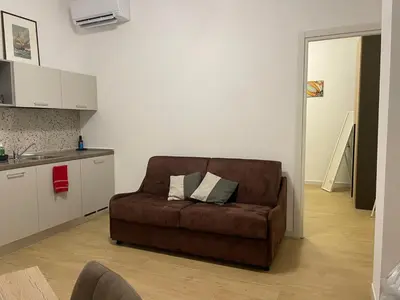 a living room with a brown couch in a kitchen at Condottieri's Hidden Home - Metro C direct to Colosseum in Rome
