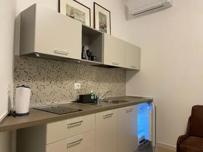 a kitchen with white cabinets and a sink at Condottieri's Hidden Home - Metro C direct to Colosseum in Rome