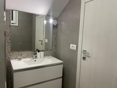 a bathroom with a white sink and a mirror at Condottieri's Hidden Home - Metro C direct to Colosseum in Rome