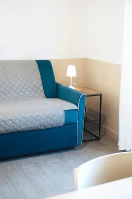 a living room with a blue couch and a table at Cozy Apartment in the heart of Garbatella in Rome