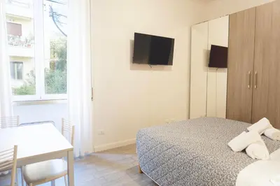 a bedroom with a bed and a tv on the wall at Cozy Apartment in the heart of Garbatella in Rome