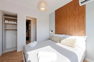 a bedroom with a white bed with a wooden wall at Sangió - Lovely Home in Rome in Rome