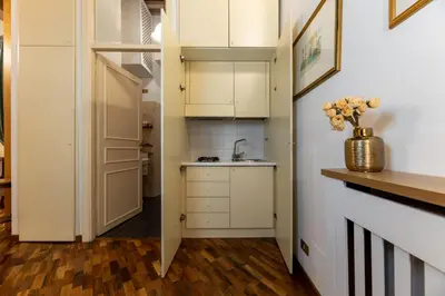 a small kitchen with white cabinets and a sink at Navona Sweet Loft in Rome