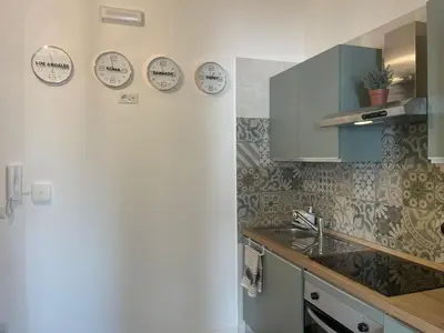 a kitchen with clocks on the wall and a sink at Appartamento 2 bagni, 2 camere a Piramide ostiense in Rome