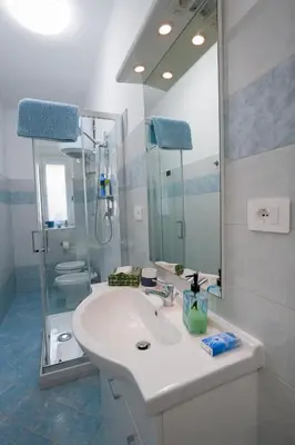 a white bathroom with a sink and a mirror at Camelia's Garden in Rome