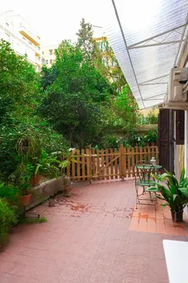 a patio with a bench and a wooden fence at Camelia's Garden in Rome