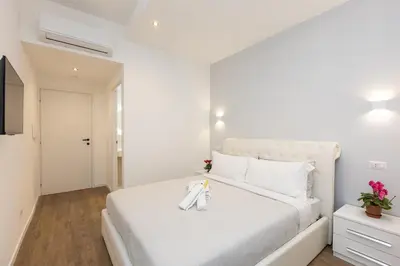 a bedroom with a white bed with a pair of shoes on it at TRASTEVERE PALACE GUEST House in Rome