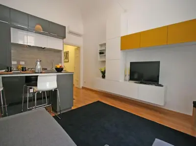 a living room with a kitchen and a television at Suite Cernaia Holidays in Rome