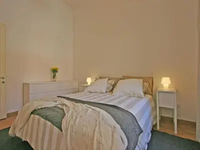 a bedroom with a bed with two tables and two lamps at Suite Cernaia Holidays in Rome