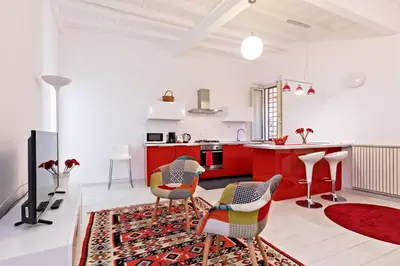 a kitchen with red cabinets and chairs in a room at Suite Boschetto Holidays in Rome