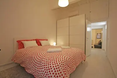 a bedroom with a bed with a red and white comforter at Suite Boschetto Holidays in Rome