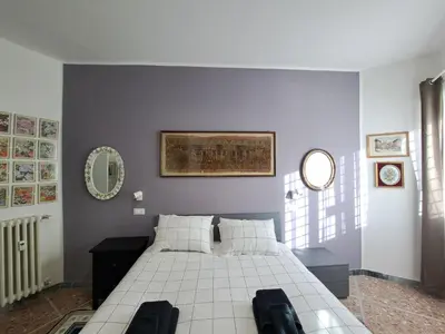 a bedroom with a white bed and a mirror at Appartamento Prenestina 74 in Rome