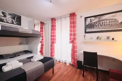 a kitchen and living room with a table and a red couch at Trastevere luxury apartment in Rome