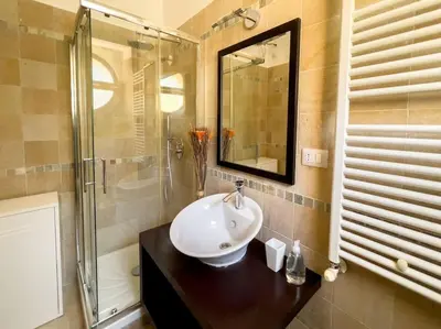 a bathroom with a sink and a glass shower at Gozzadini Apartment in Rome