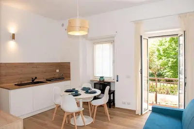 a kitchen and living room with a table and chairs at Gozzadini Apartment in Rome