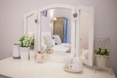 a mirror on top of a white counter with plants at B&B Vatican's Keys in Rome