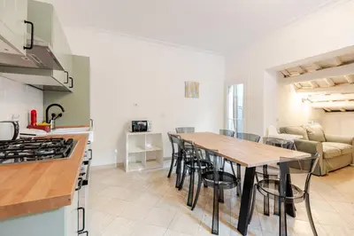 a kitchen and living room with a wooden table and chairs at Campo de Fiori - Casa Storica 4bdr con Terrazza in Rome