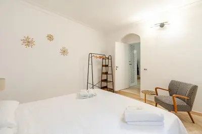 a white room with a bed and two chairs at Campo de Fiori - Casa Storica 4bdr con Terrazza in Rome