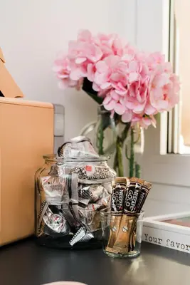 a jar with a vase with pink flowers on a table at Maison Pesca in Rome