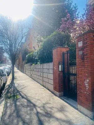 a sidewalk with a brick fence and a tree at Maison Pesca in Rome