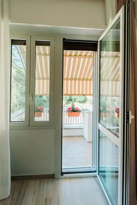 an empty room with sliding glass doors and a balcony at Maison Pesca in Rome