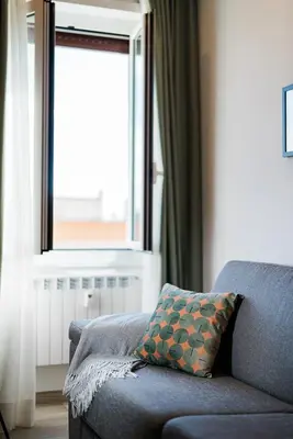 a blue couch in a living room with a window at Maison Salvia in Rome