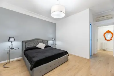 a white bedroom with a bed and a table at Casa degli Dei in Rome