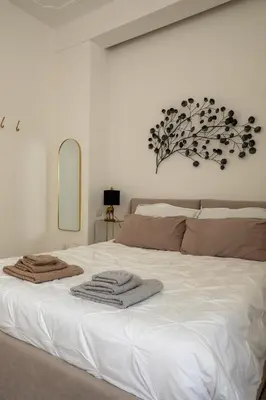 a bedroom with a white bed with towels on it at UrbanPiramide - Roma in Rome