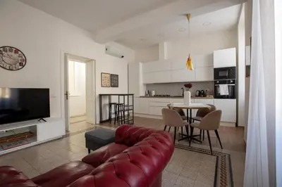 a living room with a red leather couch and a table at UrbanPiramide - Roma in Rome