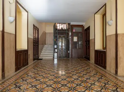 an empty hallway with doors and a tile floor at UrbanPiramide - Roma in Rome