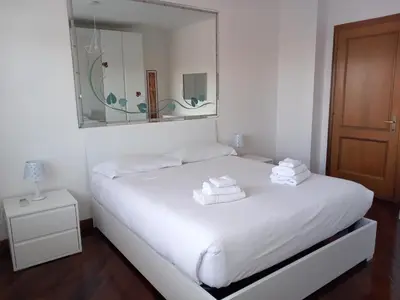 a white bed with towels on it in a room at St Peter's view penthouse 300 mt metro A stop in Rome