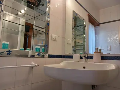 a bathroom with a white sink and a mirror at St Peter's view penthouse 300 mt metro A stop in Rome