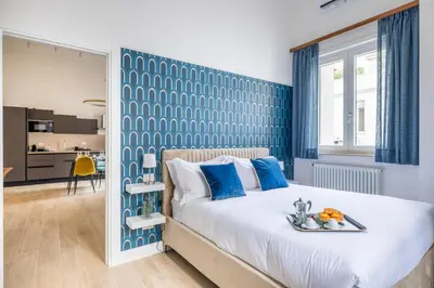 a bedroom with a large bed with a blue accent wall at Gianicolo Trastevere Exclusive Apartments in Rome