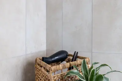 a black hair dryer in a basket next to a plant at Gianicolo Trastevere Exclusive Apartments in Rome