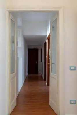 an empty hallway with two doors and wood floors at Rossovino a Roma in Rome