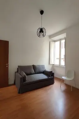 a living room with a couch and a window at Rossovino a Roma in Rome