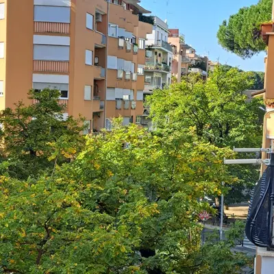 a tall apartment building with trees in front of it at Giovanni Home Porta Metronia in Rome