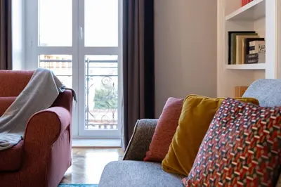 a living room with two chairs and an open door at Migliori Collection Suites Via Veneto in Rome