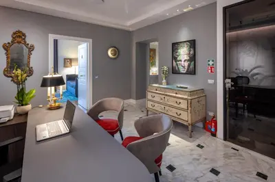 a living room with a desk with a laptop on it at Migliori Collection Suites Via Veneto in Rome
